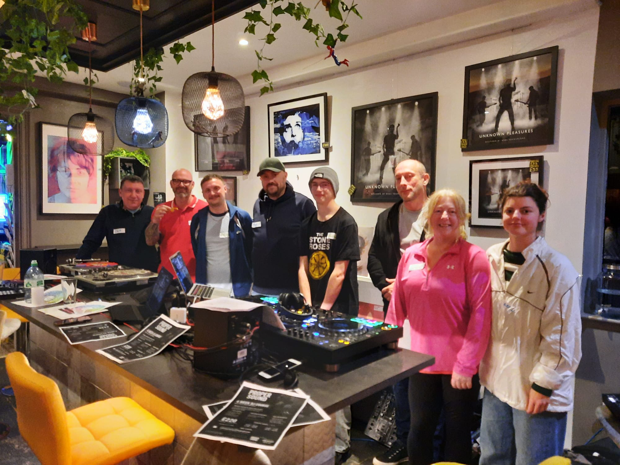 Adult DJ course group gathered around the decks inside Proper Sound in Macclesfield